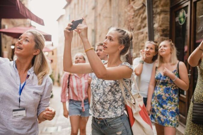 Un groupe de touristes en visite guidée prend des photos tout en profitant d'avoir du temps libre.