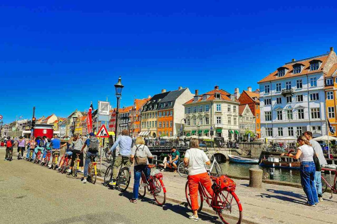 Cyclistes à Copenhague le long d’un canal près de Nyhavn, illustrant comment se déplacer à Copenhague sans voiture.